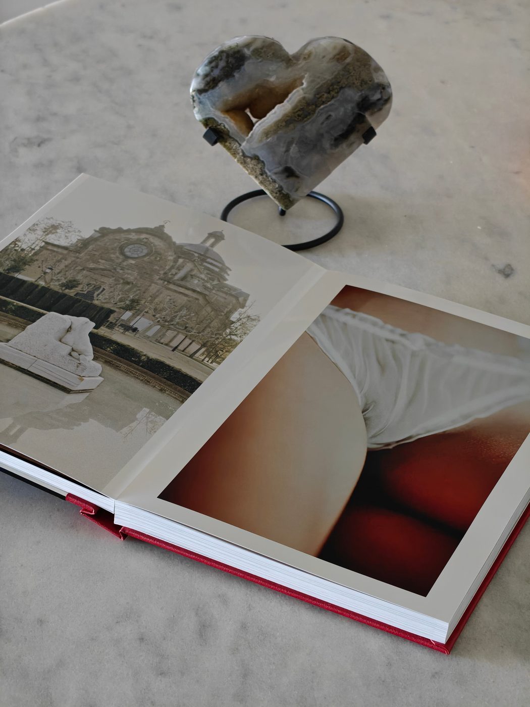 Open NiNE photobook showing a sculpture and reclining nude photograph