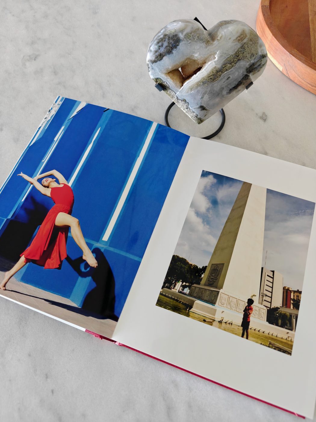 NiNE photobook spread showing a woman in red against a blue wall and a cityscape